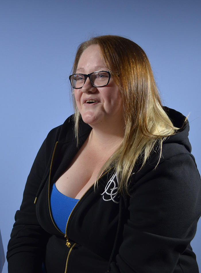 Laughing woman with glasses in a black hoodie at Highland Laser Clinic